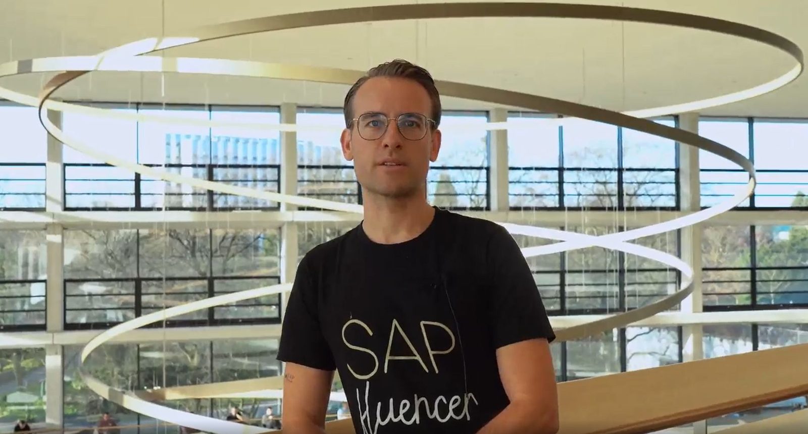 Daniel Chrobot im SAPfluencer-Shirt vor der Lichtskulptur im SAP-Foyer